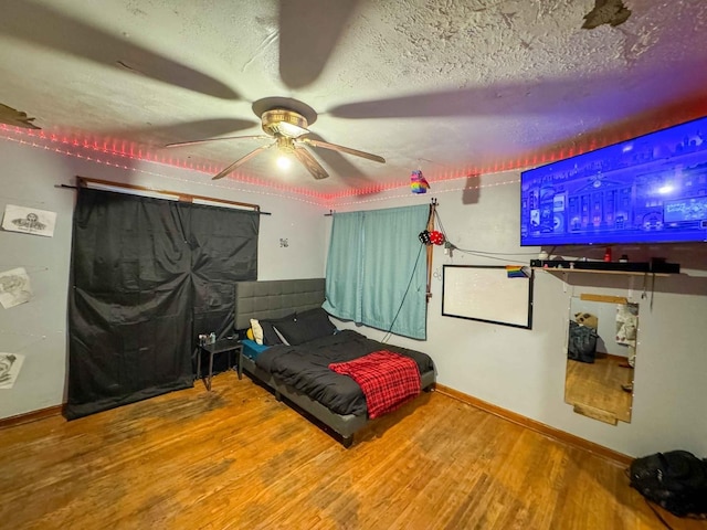 bedroom featuring wood-type flooring, a textured ceiling, and ceiling fan