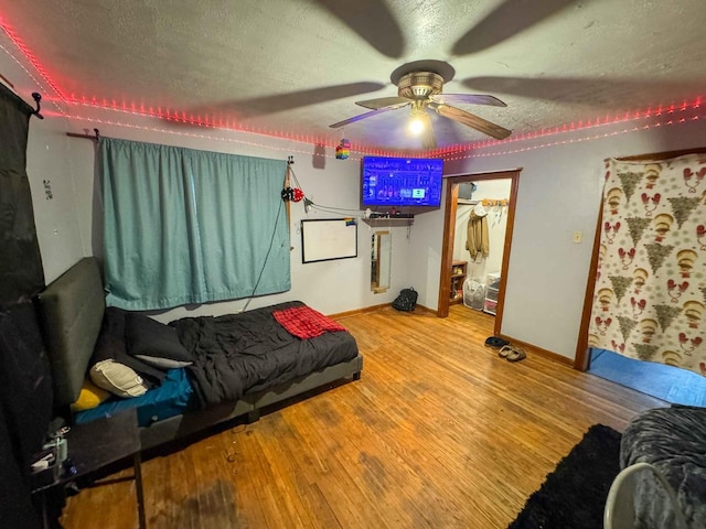 living room featuring a textured ceiling, hardwood / wood-style flooring, and ceiling fan