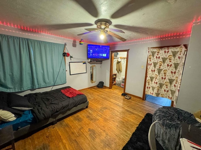 bedroom featuring ceiling fan, a closet, light hardwood / wood-style floors, and a textured ceiling