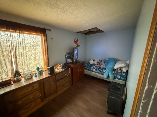 bedroom featuring a textured ceiling and dark hardwood / wood-style flooring