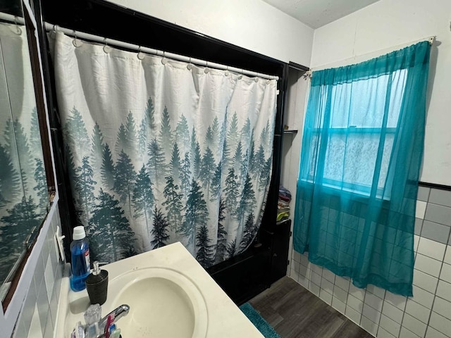 bathroom featuring hardwood / wood-style flooring, sink, and shower / tub combo