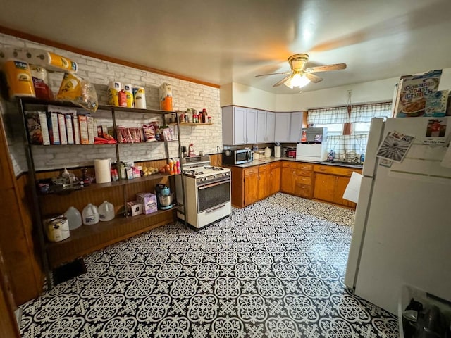 kitchen featuring white appliances, ceiling fan, and brick wall