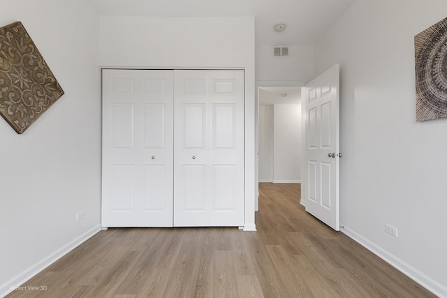 unfurnished bedroom featuring a closet and light wood-type flooring