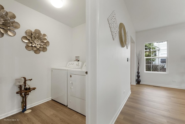 laundry room featuring washer and dryer and light wood-type flooring