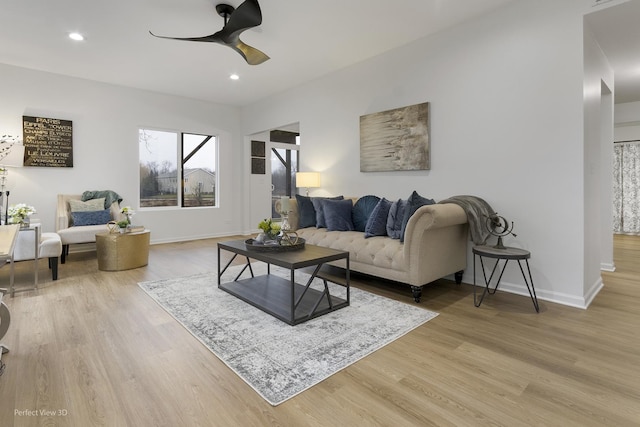 living room with light wood-type flooring and ceiling fan