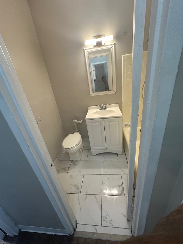 bathroom featuring toilet, vanity, and a bath