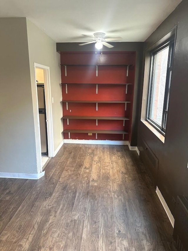 interior space with dark wood-type flooring, ceiling fan, and radiator heating unit