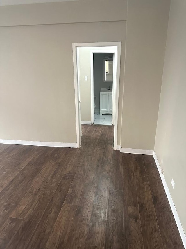 unfurnished room with dark wood-type flooring