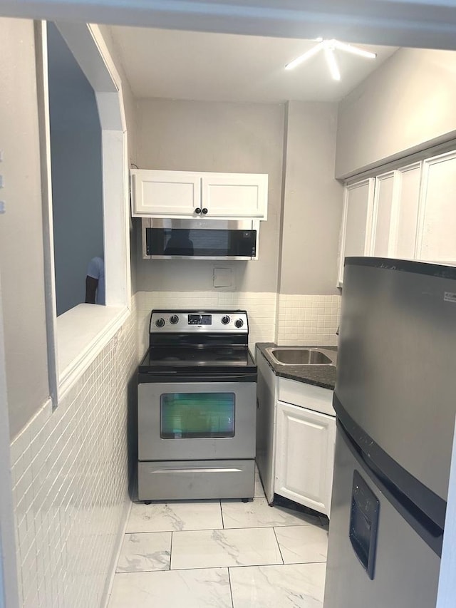 kitchen featuring white cabinets, appliances with stainless steel finishes, and sink