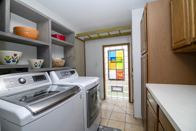 laundry room with independent washer and dryer, cabinets, and light tile patterned floors