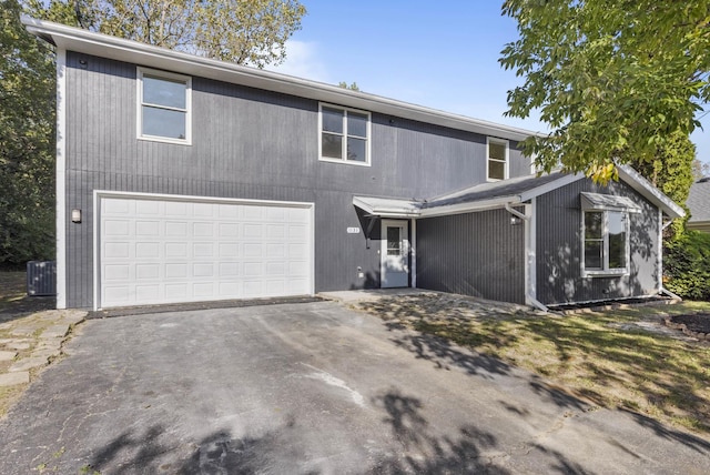 front of property featuring cooling unit and a garage