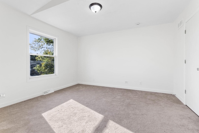 empty room with light colored carpet and vaulted ceiling