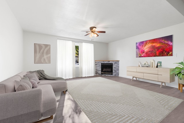 living room with ceiling fan, a fireplace, and hardwood / wood-style flooring