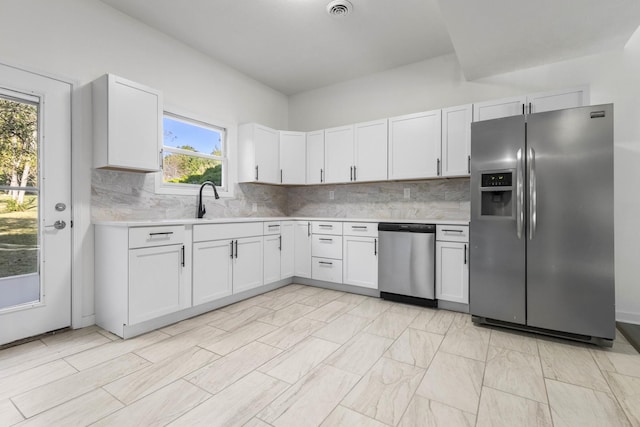 kitchen with tasteful backsplash, white cabinetry, and stainless steel appliances