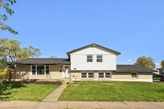 tri-level home with covered porch and a front lawn