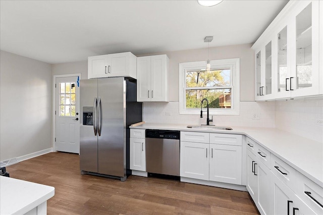 kitchen featuring white cabinets, decorative light fixtures, sink, and stainless steel appliances