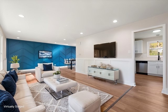 living room featuring sink and light hardwood / wood-style floors