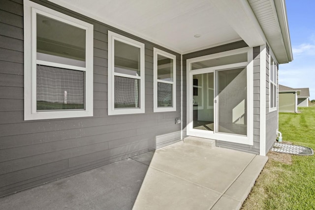 property entrance with a yard and a patio area