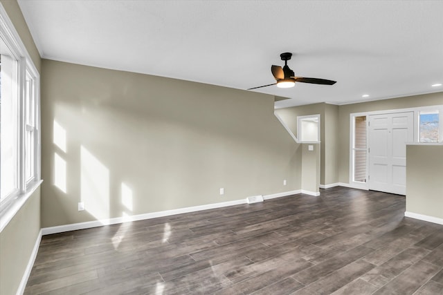 unfurnished living room featuring ceiling fan and dark wood-type flooring