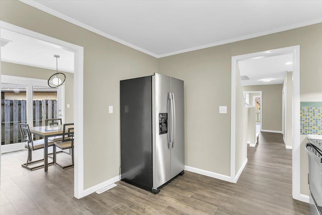 kitchen with stove, crown molding, stainless steel fridge, decorative light fixtures, and wood-type flooring