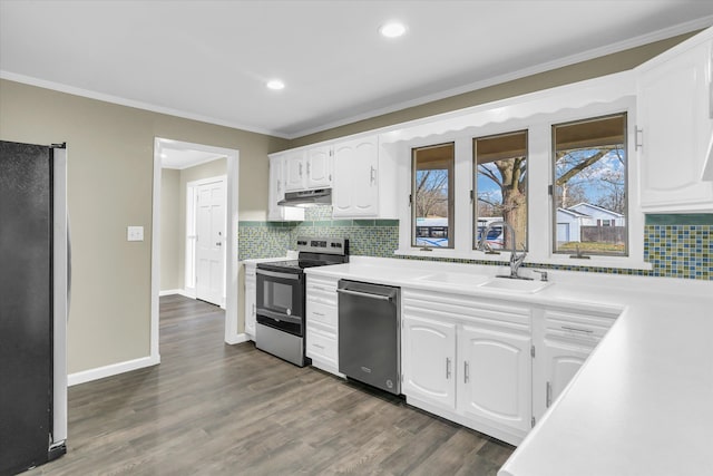 kitchen with dark wood-type flooring, sink, ornamental molding, appliances with stainless steel finishes, and white cabinetry