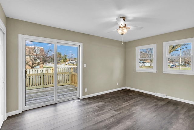 unfurnished room featuring dark hardwood / wood-style flooring, ceiling fan, and plenty of natural light