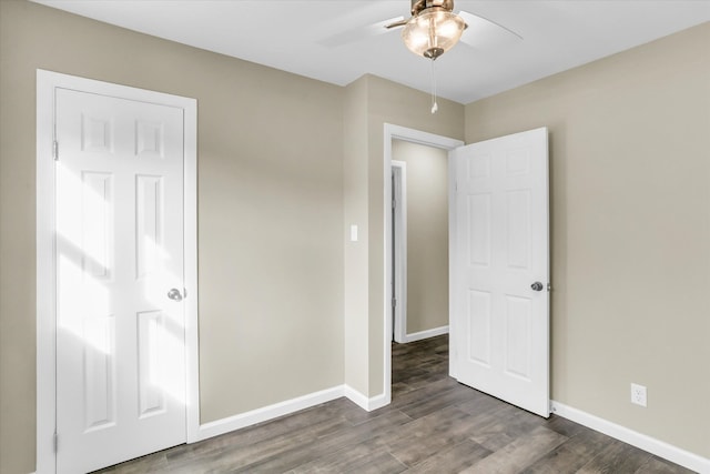 unfurnished bedroom featuring ceiling fan and dark hardwood / wood-style floors