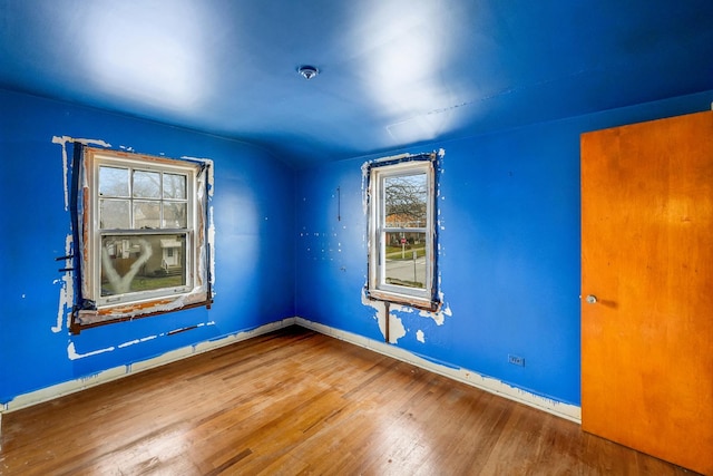 empty room with lofted ceiling and wood-type flooring