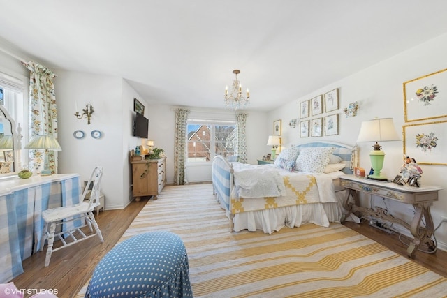 bedroom featuring multiple windows, light hardwood / wood-style flooring, and an inviting chandelier