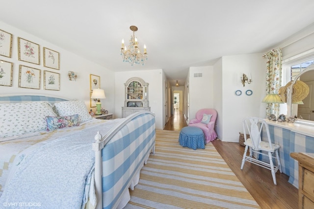 bedroom featuring a notable chandelier and hardwood / wood-style flooring