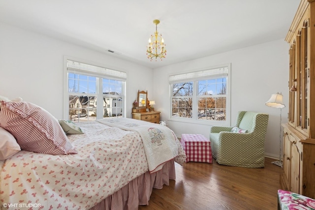 bedroom with dark hardwood / wood-style floors and a chandelier