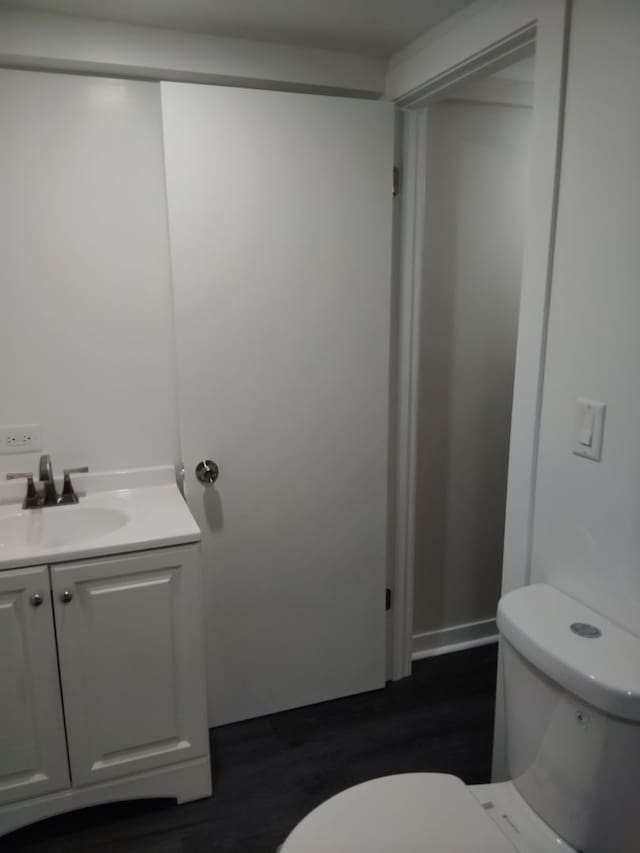 bathroom featuring vanity, hardwood / wood-style flooring, and toilet