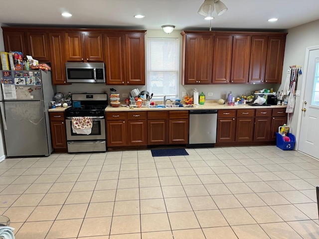 kitchen with sink, light tile patterned floors, and appliances with stainless steel finishes