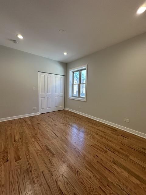 unfurnished bedroom with hardwood / wood-style floors and a closet