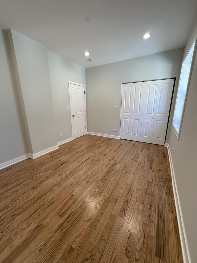 unfurnished bedroom featuring a closet and light hardwood / wood-style flooring