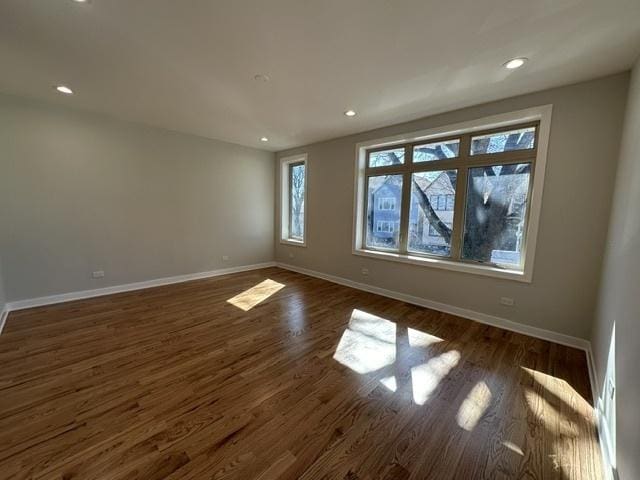 unfurnished room with dark hardwood / wood-style flooring