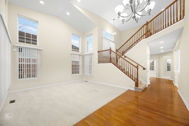 interior space featuring baseboards, a high ceiling, and stairs