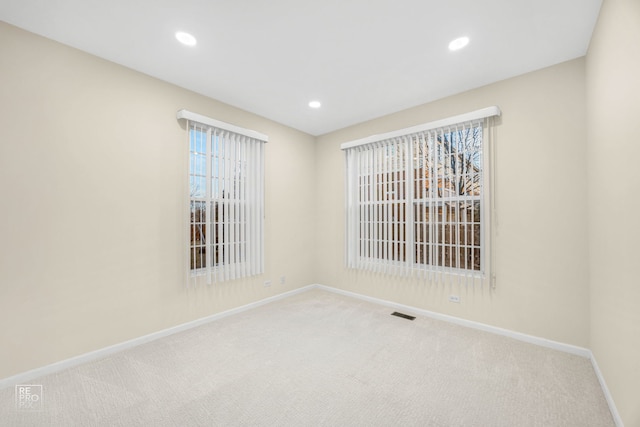 carpeted empty room with baseboards and recessed lighting