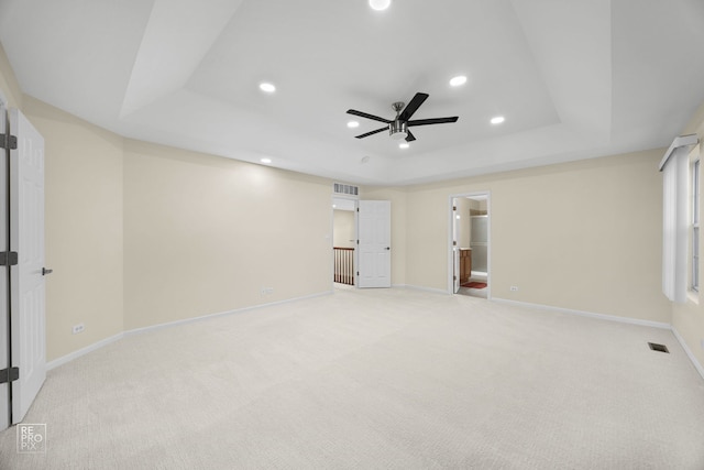 interior space with visible vents, a tray ceiling, baseboards, and recessed lighting