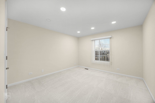 unfurnished room with baseboards, recessed lighting, visible vents, and light colored carpet