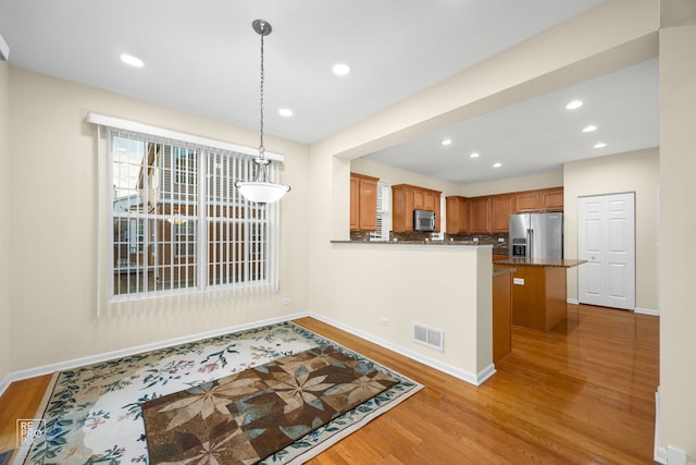 kitchen featuring visible vents, stainless steel appliances, wood finished floors, and pendant lighting