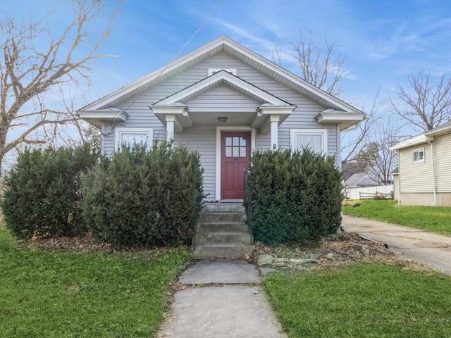 bungalow-style home with a front lawn