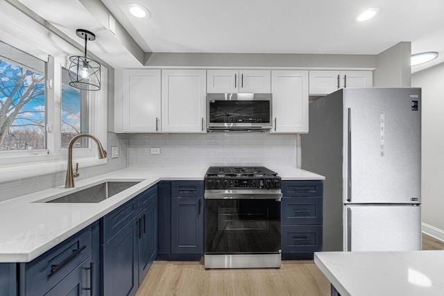 kitchen with white cabinets, sink, blue cabinets, and stainless steel appliances