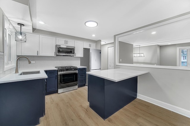 kitchen with decorative backsplash, stainless steel appliances, sink, light hardwood / wood-style flooring, and white cabinets