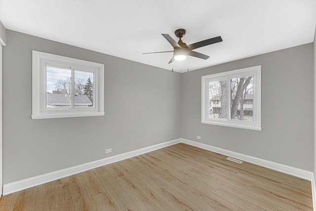 spare room with ceiling fan, a healthy amount of sunlight, and light wood-type flooring