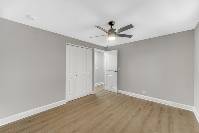 unfurnished bedroom featuring a closet, light hardwood / wood-style flooring, and ceiling fan