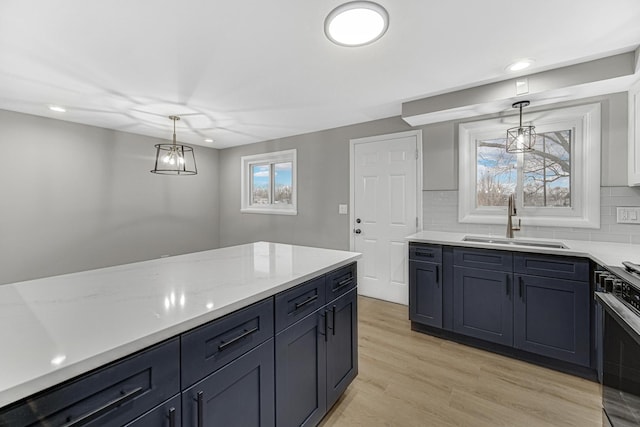 kitchen with tasteful backsplash, light hardwood / wood-style flooring, hanging light fixtures, and sink