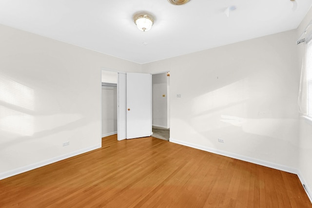 unfurnished bedroom featuring a closet and hardwood / wood-style flooring