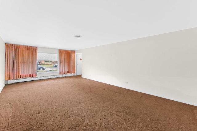 carpeted spare room featuring a baseboard heating unit