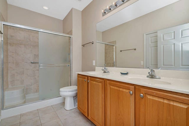 bathroom featuring toilet, vanity, tile patterned floors, and an enclosed shower